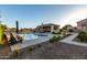 Inviting backyard with a pool, outdoor kitchen, and ample seating for entertaining at 15753 W Christy Dr, Surprise, AZ 85379