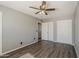 Bedroom featuring gray walls, wood-look flooring, a ceiling fan, and a closet at 15845 N 60Th Dr, Glendale, AZ 85306