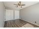 Bedroom featuring gray walls, wood-look flooring, a ceiling fan, and a closet at 15845 N 60Th Dr, Glendale, AZ 85306
