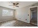 Bedroom featuring gray walls, wood-look flooring, a ceiling fan, and an entry door at 15845 N 60Th Dr, Glendale, AZ 85306