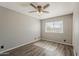 Bedroom featuring gray walls, wood-look flooring, a ceiling fan, and a window at 15845 N 60Th Dr, Glendale, AZ 85306