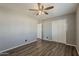 Bedroom featuring gray walls, wood-look flooring, a ceiling fan, and a closet at 15845 N 60Th Dr, Glendale, AZ 85306