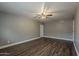 Bedroom with a ceiling fan and hardwood flooring, light walls, base trim and 2 interior doors at 15845 N 60Th Dr, Glendale, AZ 85306