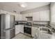 Efficient kitchen with stainless steel fridge, range, and sleek countertops at 15845 N 60Th Dr, Glendale, AZ 85306