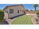 View of the home's exterior and the backyard lawn. A wall provides privacy at 16874 W Tonbridge St, Surprise, AZ 85374