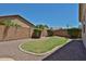 This cozy backyard features a small grass area, bushes, brick wall, and decorative rocks at 16874 W Tonbridge St, Surprise, AZ 85374