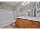 Bathroom with a tub and shower, sink, and wood cabinets at 16874 W Tonbridge St, Surprise, AZ 85374