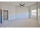 Large bedroom with a ceiling fan, window, and doorway, offering a comfortable and open space at 16874 W Tonbridge St, Surprise, AZ 85374