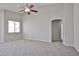 Spacious bedroom featuring neutral tones, a ceiling fan, and a window to let in natural light at 16874 W Tonbridge St, Surprise, AZ 85374