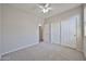 Bedroom featuring neutral carpet, ceiling fan, and sliding closet doors at 16874 W Tonbridge St, Surprise, AZ 85374