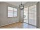 Cozy dining room with tile floors, a chandelier, a window, and a sliding glass door to the patio at 16874 W Tonbridge St, Surprise, AZ 85374