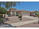 A single-story home with a landscaped front yard and a two-car garage beneath a clear blue sky at 16874 W Tonbridge St, Surprise, AZ 85374