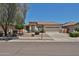Charming single-story home features a well-maintained lawn and a two-car garage beneath a clear blue sky at 16874 W Tonbridge St, Surprise, AZ 85374