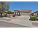 Single-story home featuring a desert-style landscape, a two-car garage, and a terracotta roof in a sunny setting at 16874 W Tonbridge St, Surprise, AZ 85374