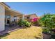 Lovely backyard features a covered patio area and is landscaped with an array of colorful potted plants and flowers at 170 E Canary Ct, San Tan Valley, AZ 85143