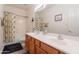 Bathroom featuring double sinks, a large mirror, and a shower-tub combo with a tropical curtain at 170 E Canary Ct, San Tan Valley, AZ 85143