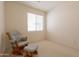 Cozy bedroom featuring a comfortable chair and ottoman placed next to a bright window at 170 E Canary Ct, San Tan Valley, AZ 85143