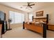 Cozy bedroom with a ceiling fan, natural light, and a comfortable queen-sized bed at 170 E Canary Ct, San Tan Valley, AZ 85143