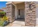 Inviting front porch with stone accents, a gray front door, and desert landscaping at 170 E Canary Ct, San Tan Valley, AZ 85143
