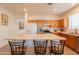 Modern eat-in kitchen with wood cabinets, stainless appliances, an island with bar seating, and tile flooring at 170 E Canary Ct, San Tan Valley, AZ 85143