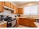 Well-lit kitchen featuring wood cabinetry, stainless steel appliances, and a view from the window at 170 E Canary Ct, San Tan Valley, AZ 85143