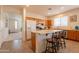 Bright eat-in kitchen with wood cabinets, stainless appliances, an island with bar seating, and tile flooring at 170 E Canary Ct, San Tan Valley, AZ 85143