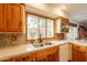 Well-lit kitchen featuring wood cabinets, quartz countertops, and a window view of the charming landscaped outdoors at 1708 E Westchester Dr, Tempe, AZ 85283
