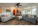 Inviting living room featuring comfortable sofas, hardwood flooring, a ceiling fan, and an open view into the backyard at 1708 E Westchester Dr, Tempe, AZ 85283
