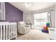 Charming bedroom with purple accents, a crib and a comfortable chair with a ceiling fan at 1744 E Fremont Rd, Phoenix, AZ 85042