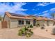 Charming home featuring a three car garage and a well-manicured front yard with desert landscaping and solar panels at 1744 E Fremont Rd, Phoenix, AZ 85042