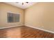 Bright bedroom featuring a large window, ceiling fan, and stylish laminate wood flooring at 18650 N 91St Ave # 3301, Peoria, AZ 85382