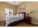 Cozy bedroom with wood flooring, a large window, and a comfortable bed with nightstand at 18650 N 91St Ave # 3301, Peoria, AZ 85382