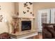 Granite fireplace in living room with butterfly decor and sliding glass door at 18650 N 91St Ave # 3301, Peoria, AZ 85382