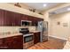 Functional kitchen featuring stainless steel appliances, granite countertops, and sleek dark wood cabinetry at 18650 N 91St Ave # 3301, Peoria, AZ 85382