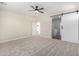 Carpeted bedroom featuring a ceiling fan and a doorway to an adjacent bathroom at 18675 W Foothill Dr, Surprise, AZ 85387