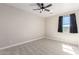 Neutral bedroom with carpet, ceiling fan, and window with dark curtains at 18675 W Foothill Dr, Surprise, AZ 85387