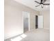 Neutral bedroom with carpet, ceiling fan, and two open doorways at 18675 W Foothill Dr, Surprise, AZ 85387