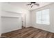 Bedroom with hard wood floor, fan, window, and open shelves at 18675 W Foothill Dr, Surprise, AZ 85387