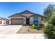 Charming single-story home featuring desert landscaping, a two-car garage, and a welcoming front entrance at 18675 W Foothill Dr, Surprise, AZ 85387