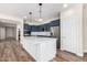 Modern kitchen with navy blue cabinets, stainless steel appliances, and a large white center island at 18675 W Foothill Dr, Surprise, AZ 85387
