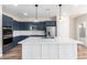 Stylish kitchen with navy cabinets, stainless steel appliances, and a white center island with a sink at 18675 W Foothill Dr, Surprise, AZ 85387