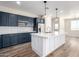 Contemporary kitchen featuring a large center island with quartz countertops and stylish pendant lighting at 18675 W Foothill Dr, Surprise, AZ 85387