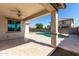 Covered patio with a ceiling fan overlooking a private pool and well-maintained backyard at 18675 W Foothill Dr, Surprise, AZ 85387
