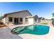 Backyard swimming pool with a tanning ledge and well-manicured travertine patio at 18675 W Foothill Dr, Surprise, AZ 85387