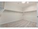 Walk-in closet with carpeted floor, white walls, and custom shelving at 18675 W Foothill Dr, Surprise, AZ 85387