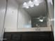 Bathroom with undermount sink, cabinetry, and a large mirror illuminated by six lights at 1927 E Hampton Ave # 260, Mesa, AZ 85204