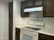 Compact kitchen featuring light countertops, brown cabinets, and white range oven at 1927 E Hampton Ave # 260, Mesa, AZ 85204