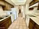 Traditional kitchen with tile flooring, white appliances, and warm wood cabinetry at 1927 E Hampton Ave # 260, Mesa, AZ 85204