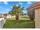 Artificial turf yard with desert landscaping and palm trees near a block wall and eaves at 1940 E Citation Ln, Tempe, AZ 85284
