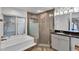 Luxurious bathroom featuring a soaking tub, glass-enclosed shower, and vanity with granite countertop at 1940 E Citation Ln, Tempe, AZ 85284
